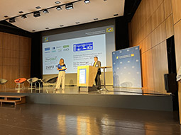 Zwei Personen stehen auf einer hellerleuchtetend Bühne. Darunter Herr Prof. Mocker, Leiter des Dachprojekts des Projektverbundes ForCYCLE II, rechts hinter einem Pult.